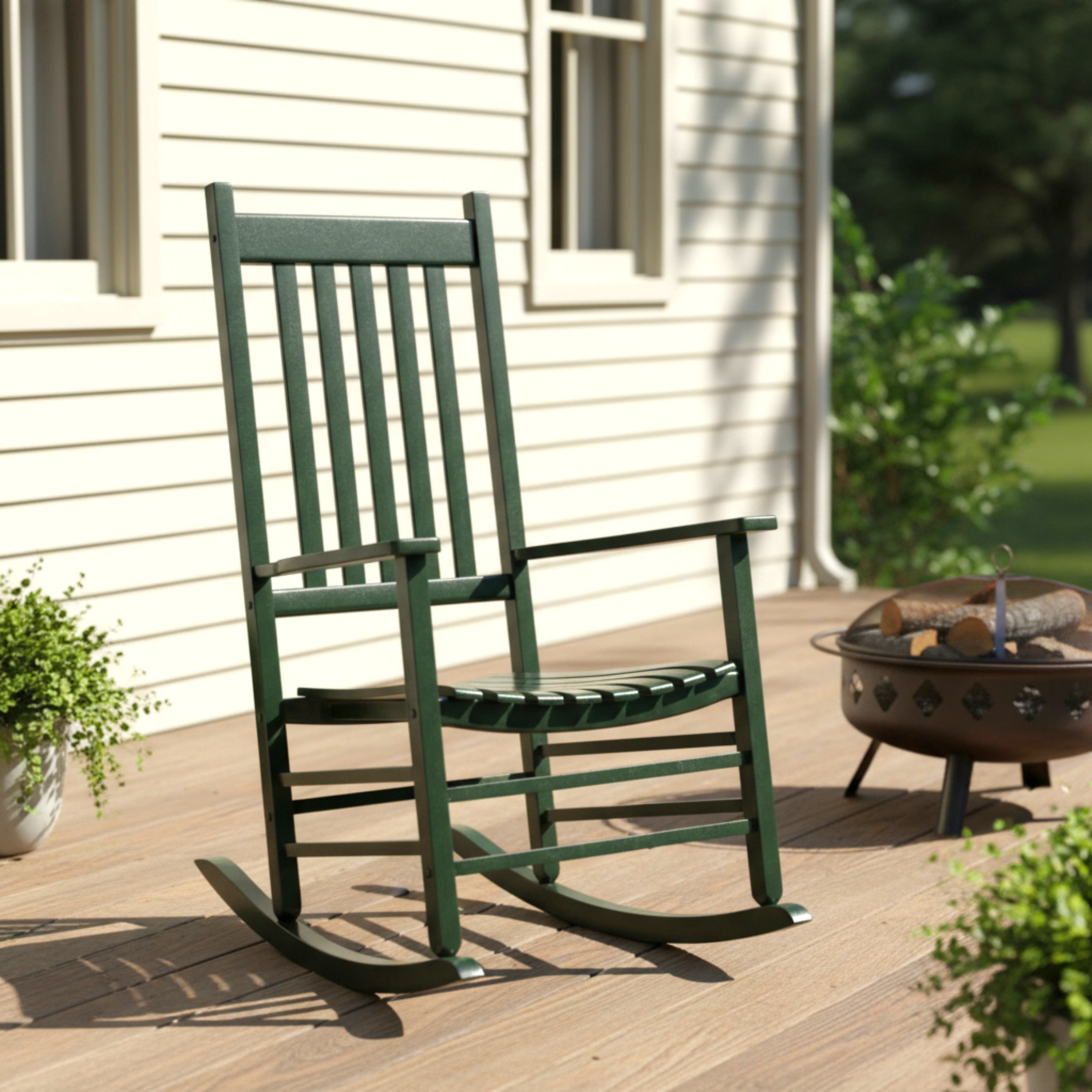 Green rocking chair on a wooden deck with a fire pit and plants in the background.