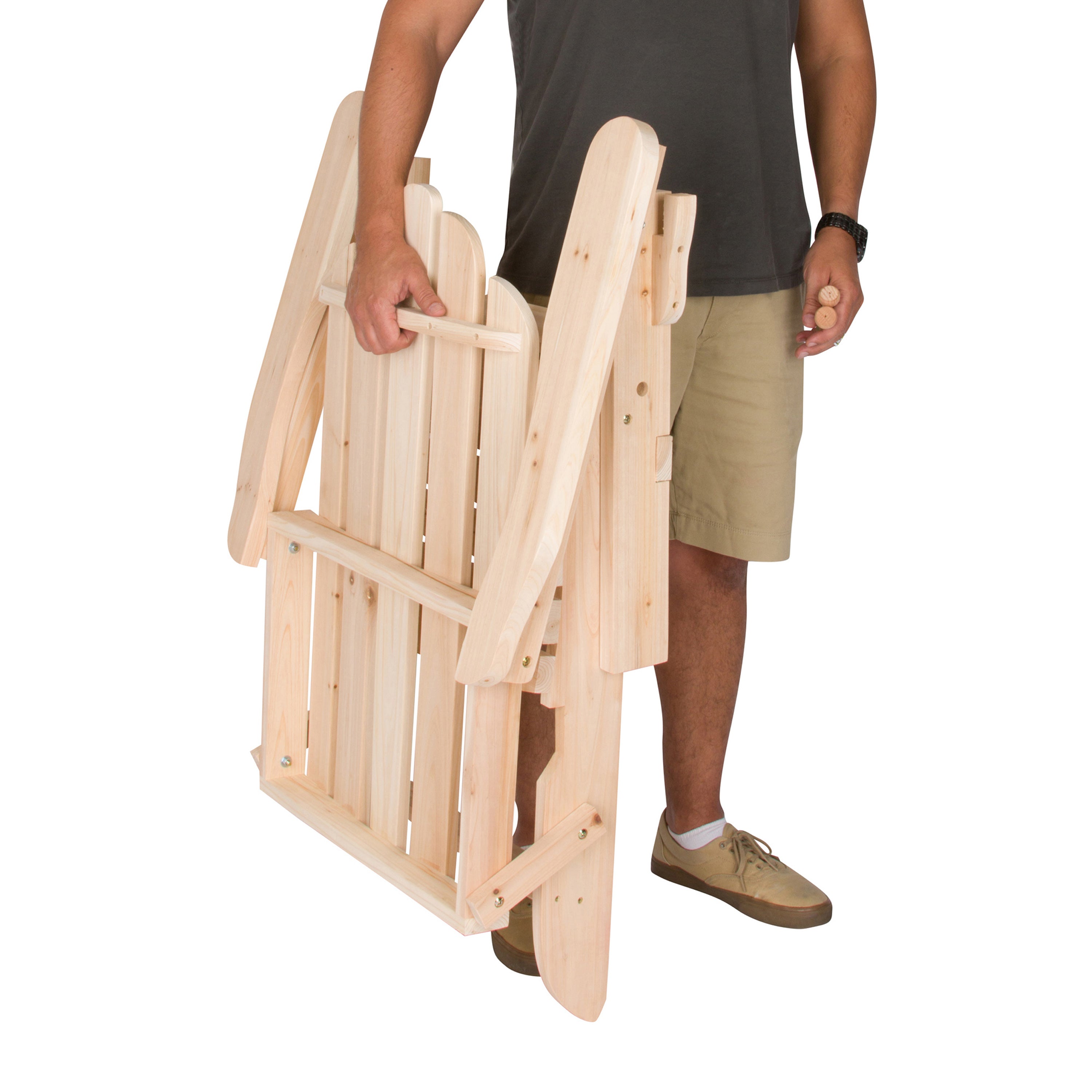 A man holding a folded light natural wood folding chair against a plain white background.