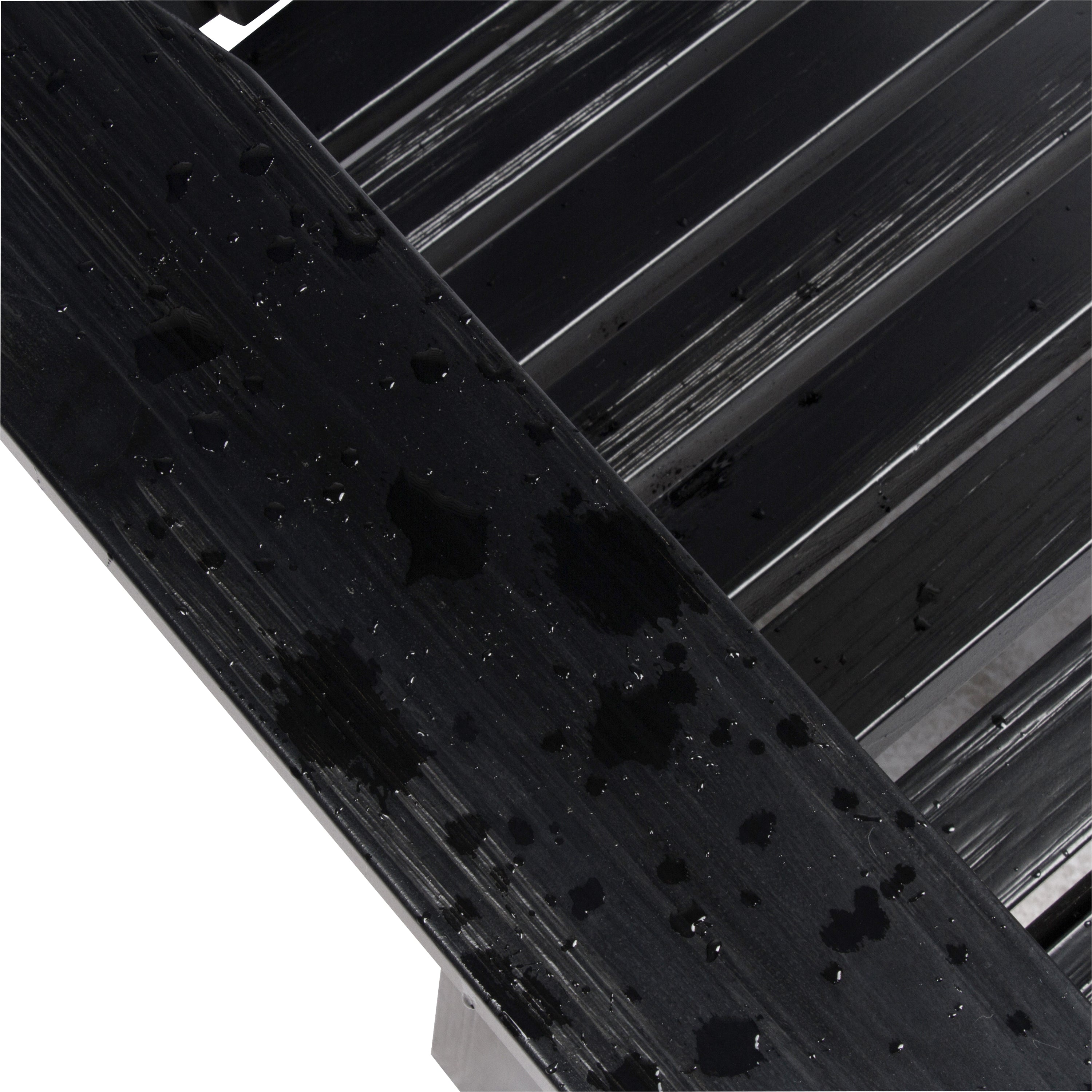 Close-up of a glossy black textured wooden slat surface showing the water resistant paint quality against a white background with diagonal black bars.