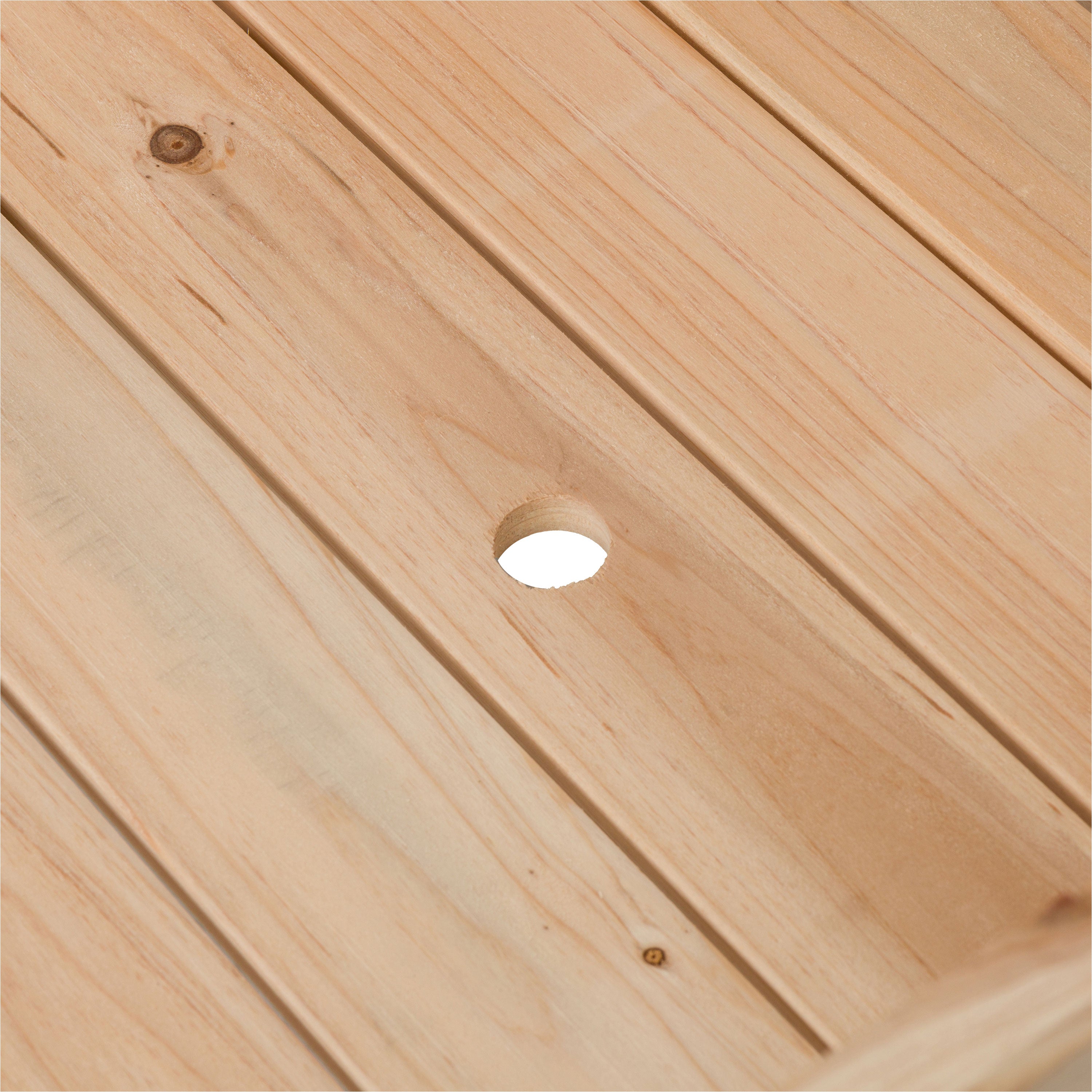 Close-up of a light natural wood slatted surface with visible wood grain, knots, and a circular cutout in the center.