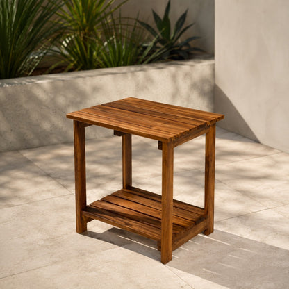 Wooden side table on a patio with plants in the background  