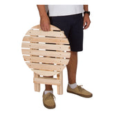Person holding a wooden folding chair on a white background 