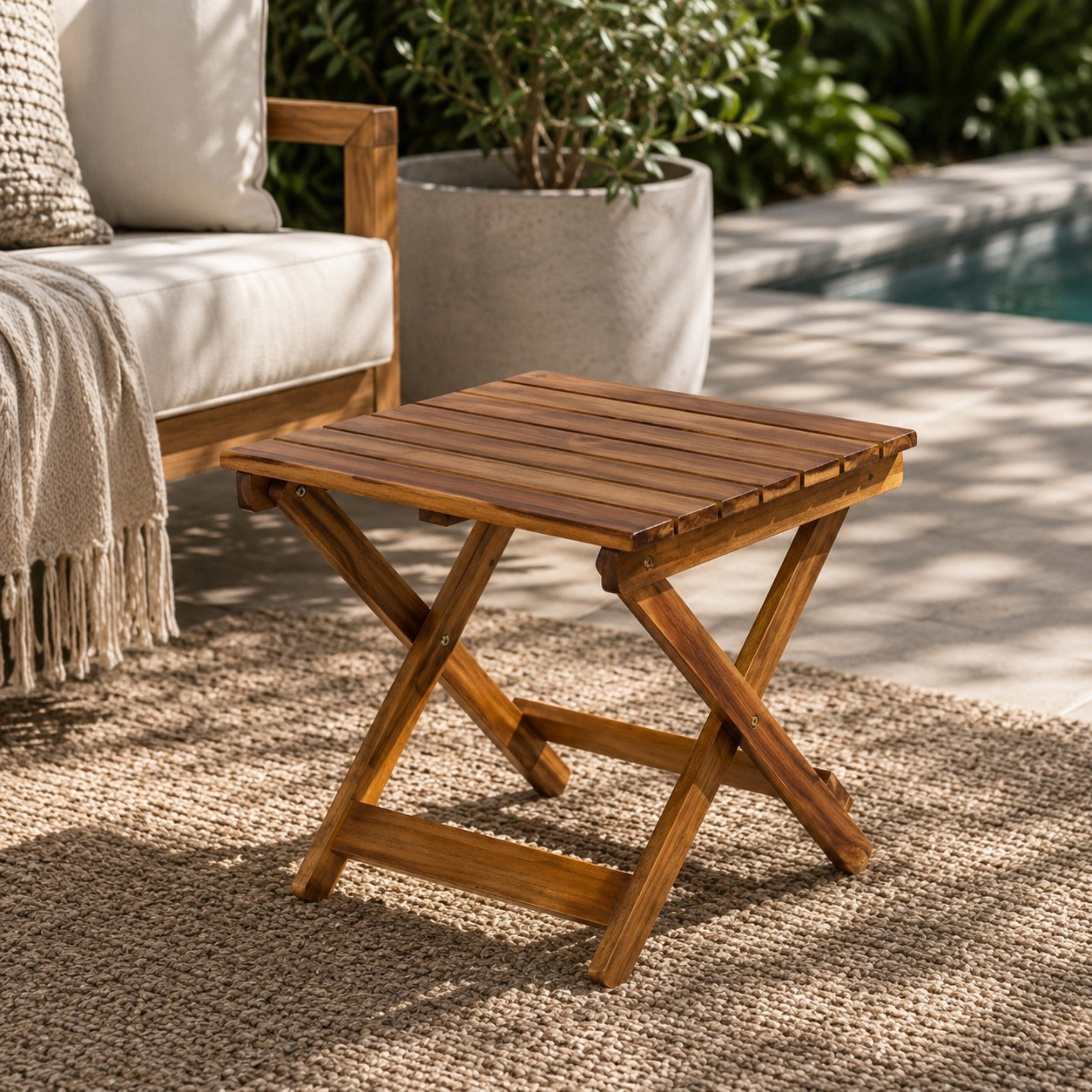Wooden folding table on a patio with outdoor furniture and plants in the background. 