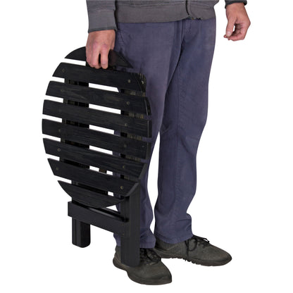 A person holding a black folding slatted bench or chair against a plain white background. 