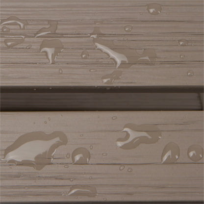 Close-up of a weathered taupe-brown wood or composite plank surface with water droplets and small puddles showing through the textured finish. 