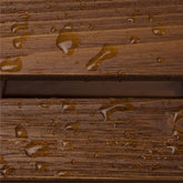 Close-up of a brown wood-grain surface with water droplets beading on top, showing a horizontal seam between two planks. 