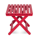A bright red folding wooden side table with a slatted top and X-frame legs, shown on a clean white background. 