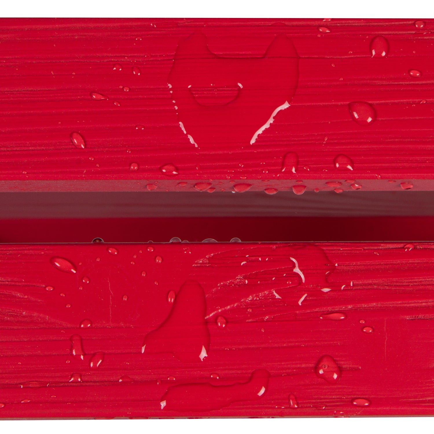 Close-up of a bright red textured surface with water droplets and a faint heart-shaped impression, likely showing a material finish or protective coating. 