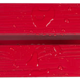 Close-up of a bright red textured surface with water droplets and a faint heart-shaped impression, likely showing a material finish or protective coating. 