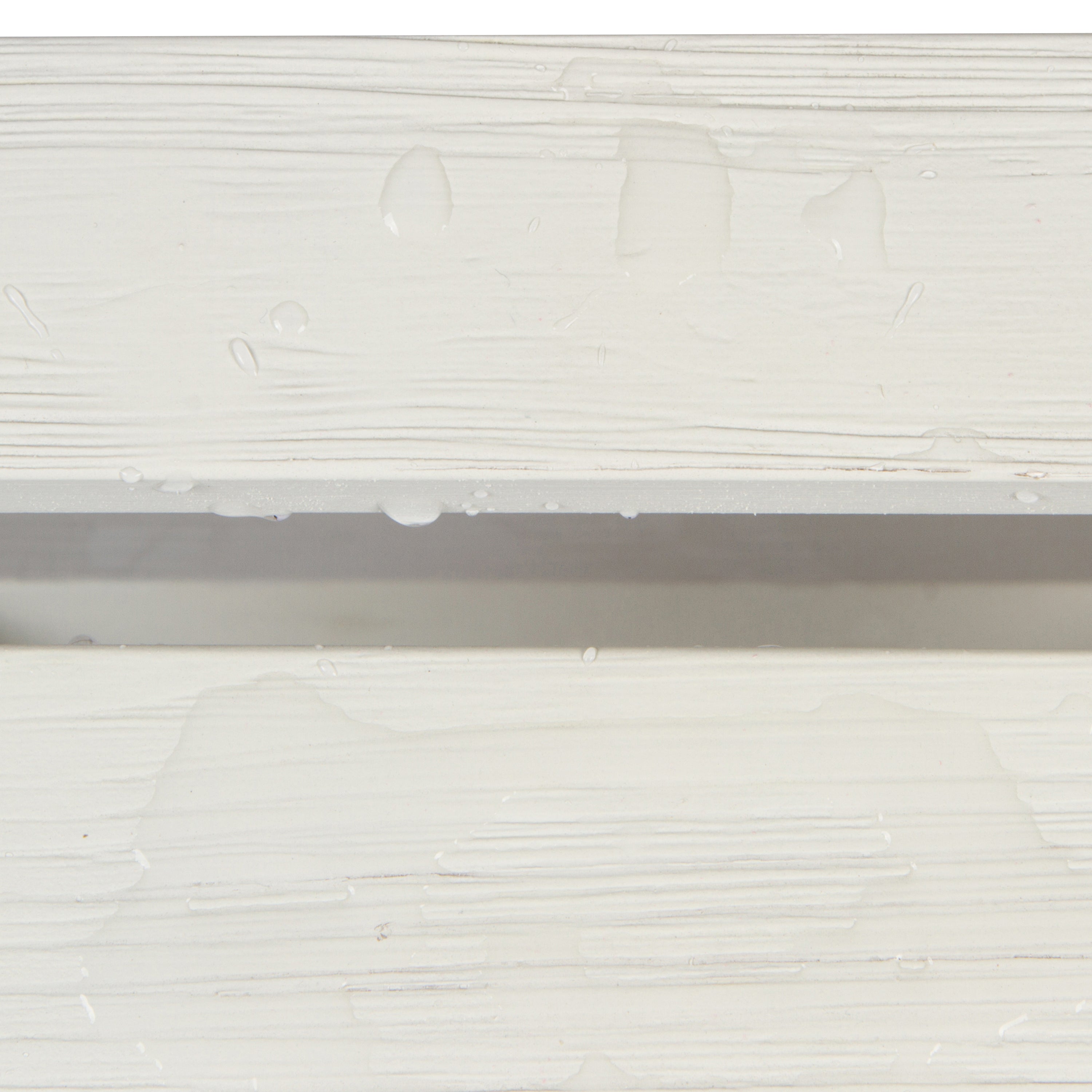 Close-up of a white textured surface with horizontal ridges and a few water droplets, showing a shallow channel or groove in the middle. 