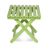 A lime green folding wooden side table with a slatted top and X-frame legs, shown on a white background. 
