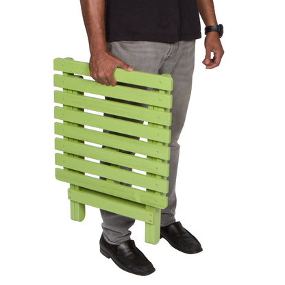 Person holding a green wooden side table against a white background 