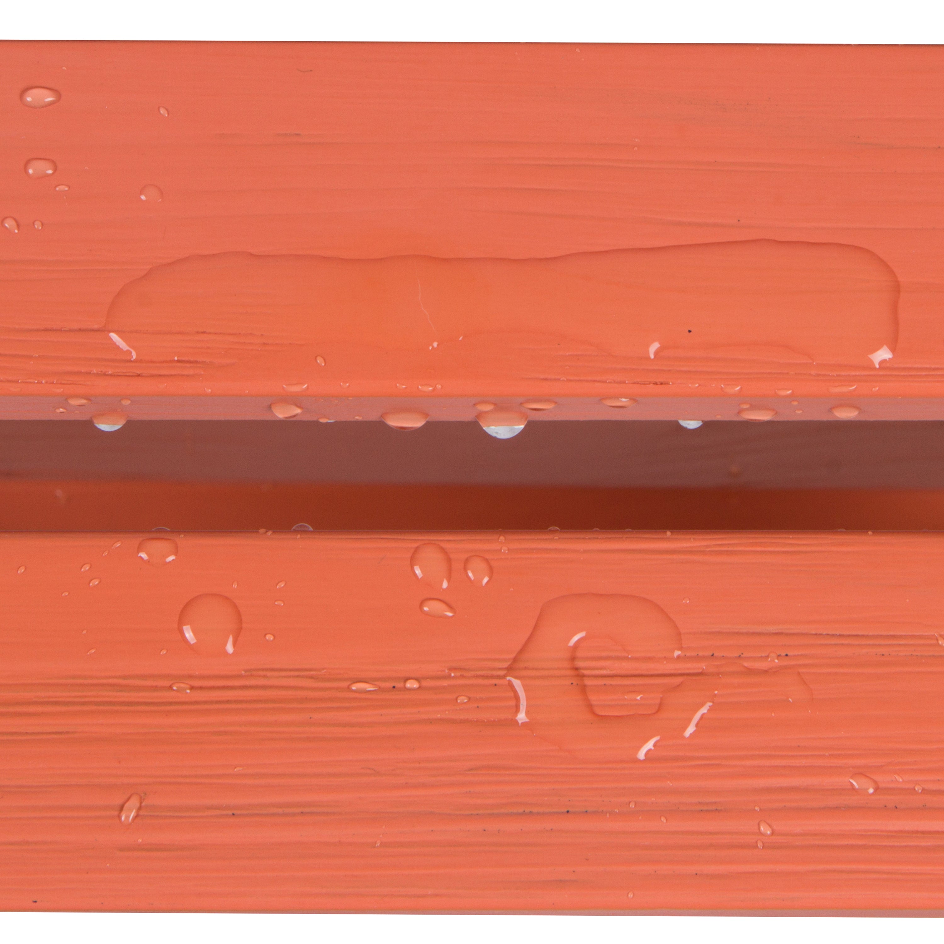 Close-up of a terracotta orange textured surface with water droplets and a water droplet beading up along the edge, demonstrating a waterproof or hydrophobic finish. 