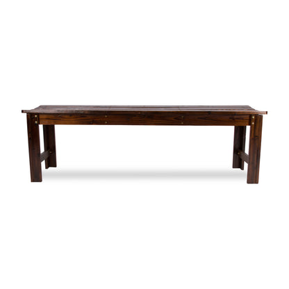 A dark brown wooden bench with a slatted seat and trestle-style legs, shown from the side against a plain white background. 