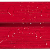 Close-up of glossy red textured material with water droplets on the surface. 