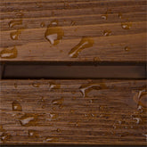 Close-up of a brown wood-grain textured surface with water droplets and a horizontal slot or groove running through the center. 
