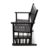 A black wooden rocking chair with a slatted seat, backrest, and armrests, shown from a side angle against a plain white background. 