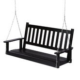 A black wooden porch swing bench suspended by silver metal chains against a plain white background. 