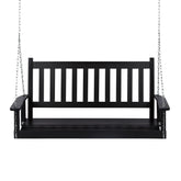 A black wooden porch swing bench suspended by silver metal chains against a plain white background. 
