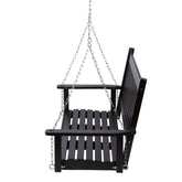 A black wooden hanging porch swing with a slatted seat, backrest, and armrests, suspended by silver metal chains against a plain white background. 