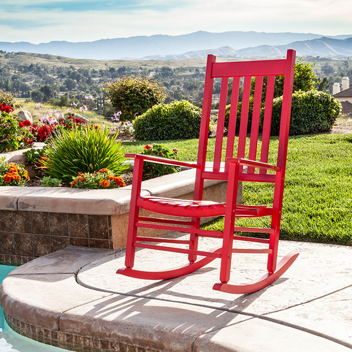 Red rocking chair on a patio with a scenic background 