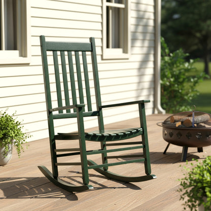 Green rocking chair on a wooden deck with a fire pit and plants in the background. 
