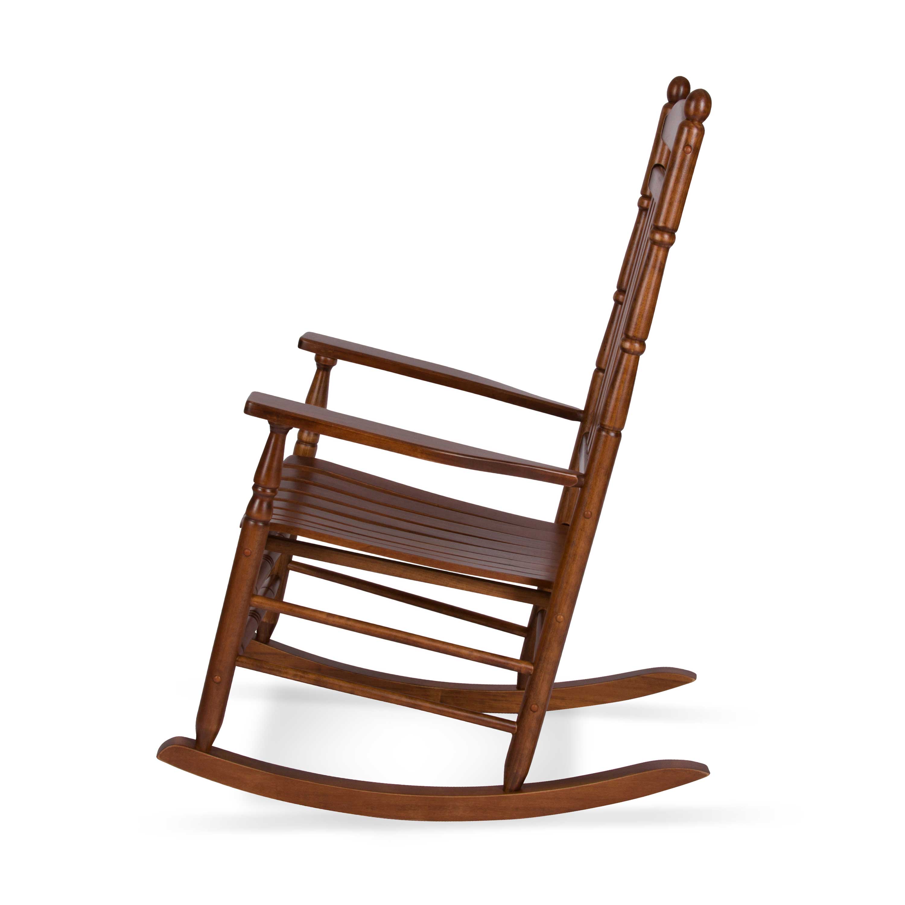 A classic wooden rocking chair with a warm brown finish, featuring a slatted seat, armrests, and a tall turned-back spindle backrest, shown from a three-quarters angle on a white background. 