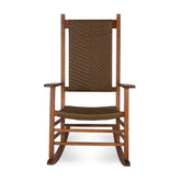 A wooden rocking chair with a tall woven brown wicker backrest and seat, shown against a plain white  background. 