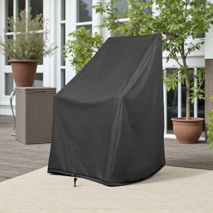 A black outdoor patio chair cover standing upright on a light beige rug on a wooden deck, with potted plants and a patio setting in the background. 