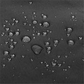 Close-up of a dark gray textured fabric surface with multiple water droplets resting on top, showing a water-repellent or waterproof effect. 