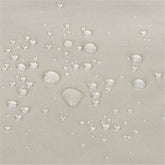 Close-up of a light gray fabric surface with scattered clear water droplets showing a repellent, water-repellant finish. 