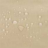 Close-up of a khaki textured fabric surface with clear water droplets beaded on top, demonstrating a water-repellent or waterproof finish. 