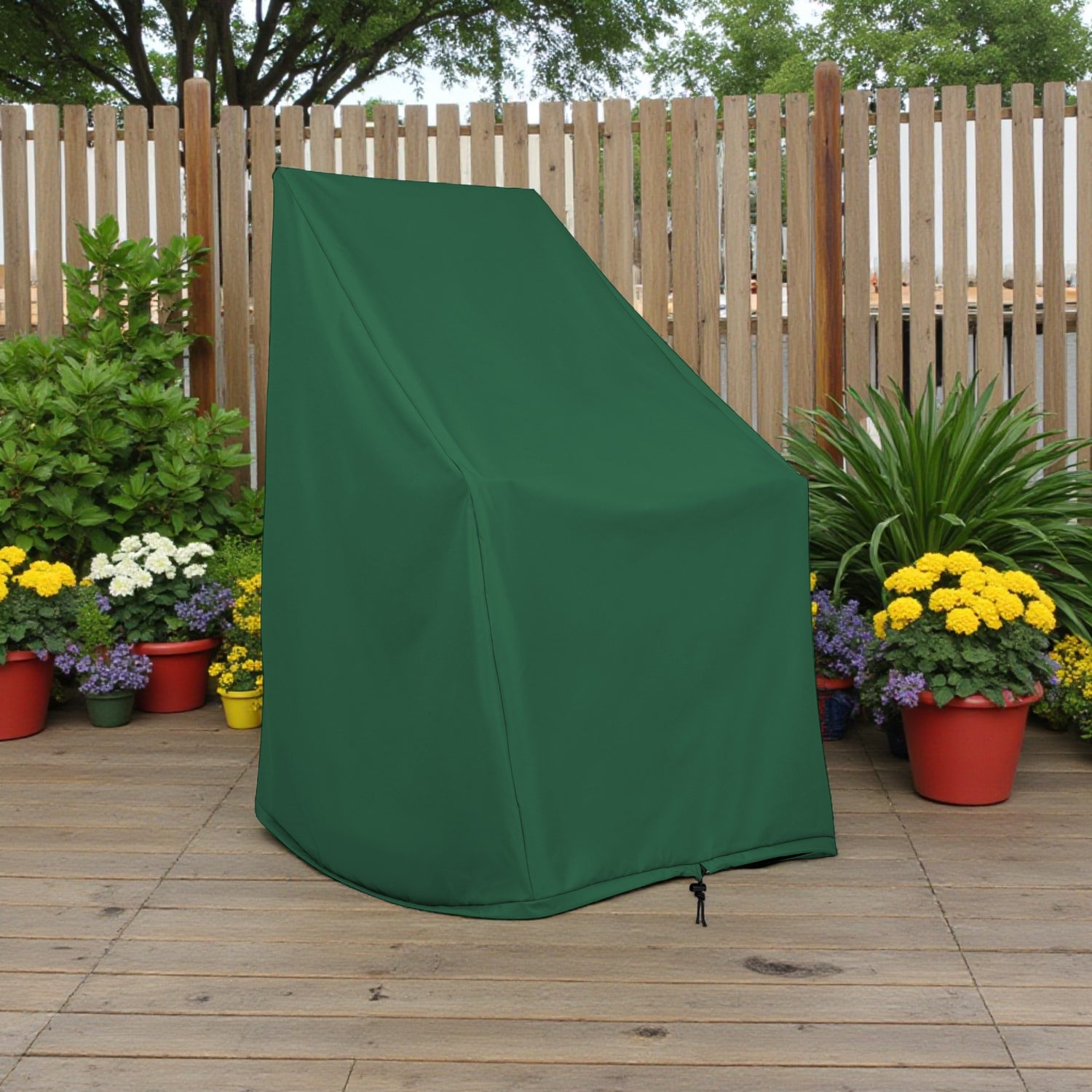 A dark green outdoor garden chair cover standing on a wooden deck in front of a wooden fence, surrounded by potted flowers and plants. 