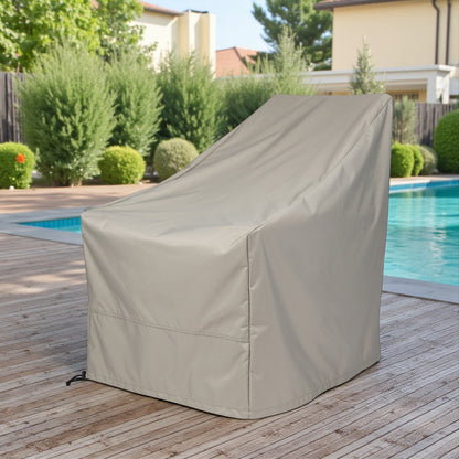 A gray patio furniture cover, likely for a lounge chair or small table, shown outdoors on a wooden deck next to a swimming pool with green shrubs and houses in the background. 