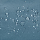 Close-up of a textured blue fabric surface with scattered clear water droplets showing a water-repellent  effect. 