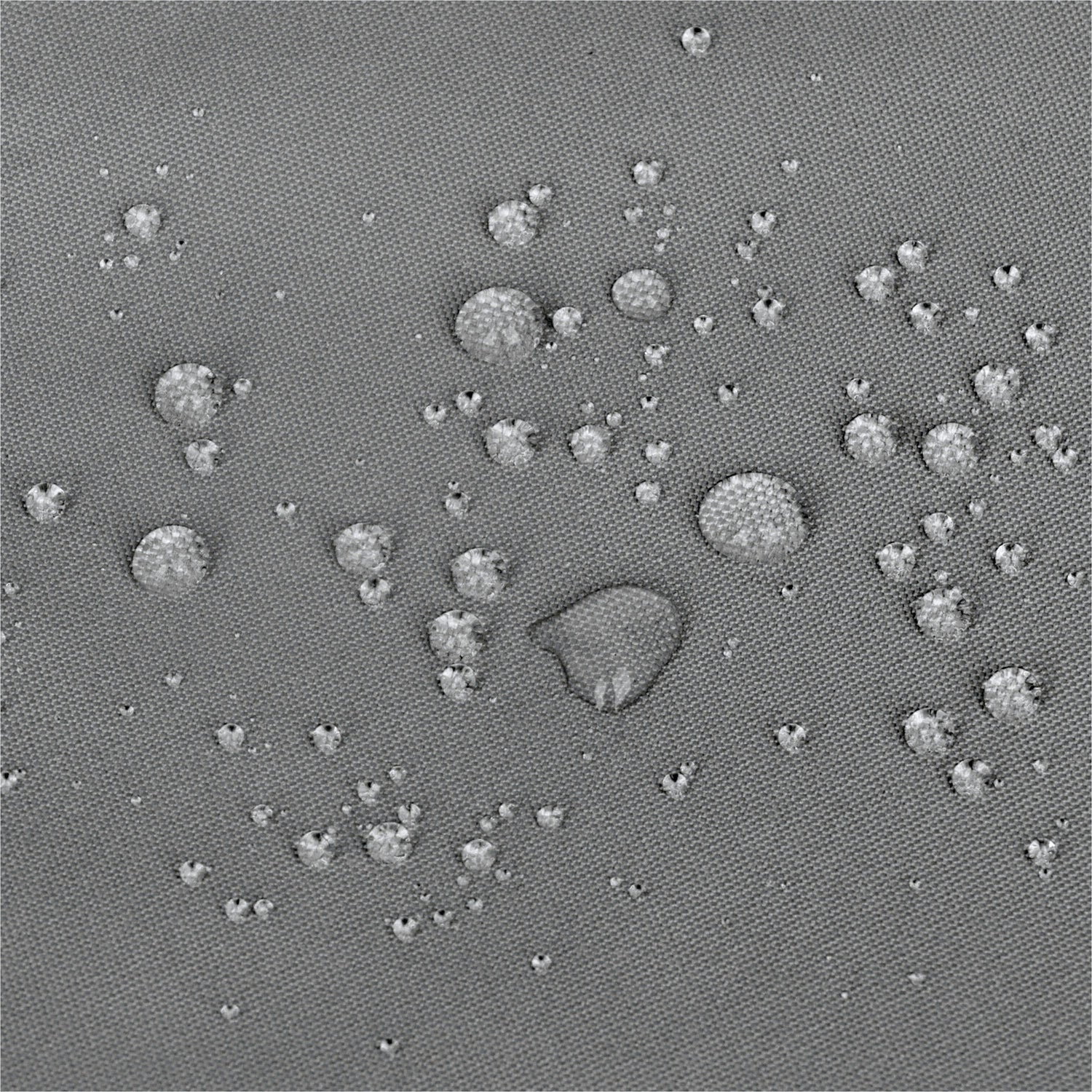 A close-up of a gray textured surface with scattered small raised circular bumps and a few larger bumps, resembling a fabric or material swatch rather than a finished consumer product. 