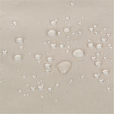 Close-up of a khaki woven fabric surface with multiple clear water droplets resting on top, showing a water-repellent or hydrophobic effect. 