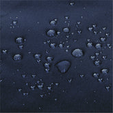 Close-up of a dark navy blue textured fabric surface with multiple water droplets resting on it. 
