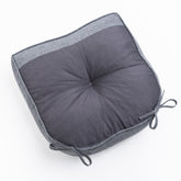 A square gray cushion with a textured mesh center and a solid heather gray fabric border, featuring tie-on corner straps, shown on a plain white background. 