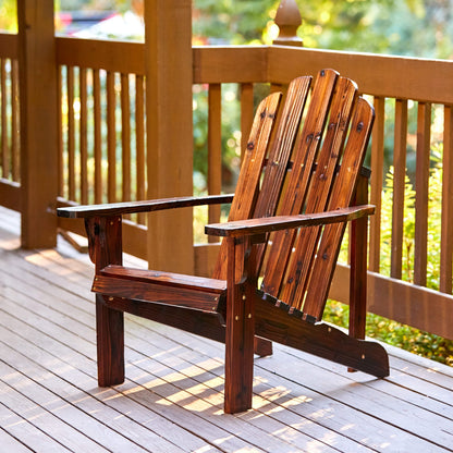 A dark brown wooden Adirondack chair placed on a wooden deck with a railing and green foliage in the background. 