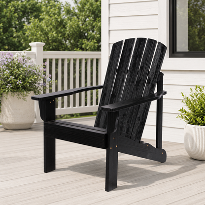 A black outdoor Adirondack chair with a slatted back and wide armrests, shown on a light deck beside a white house with potted plants. 