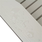Close-up of a white textured slatted surface with water droplets on a white background. 