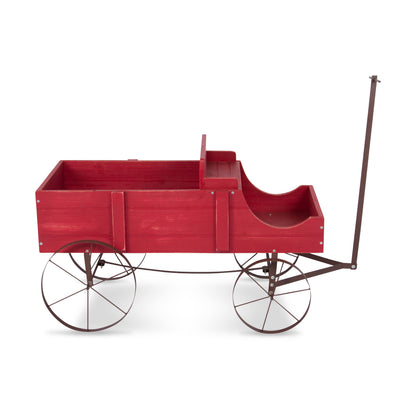 A red wooden wagon-style play structure with a curved seat, open cargo bed, and dark metal frame and wheels, shown on a plain white background. 