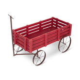 A red wooden slat wagon with dark brown metal wheels and a pull handle, shown on a clean white background. 