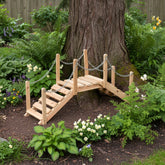 Wooden garden bridge in a lush garden setting with plants and flowers. 