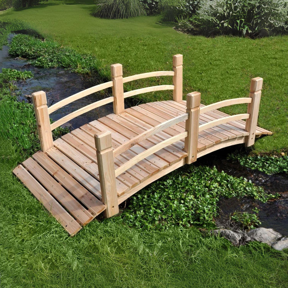 A 5ft arched wooden garden bridge with railings, shown outdoors over a stream in a grassy yard. 