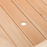 Close-up of a light natural wood slatted surface with a small circular cutout near the center. 