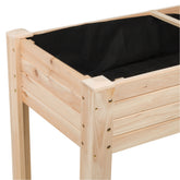 A close-up of a wooden raised garden bed frame with a black fabric liner, showing the natural wood grain and metal fasteners against a white background. 