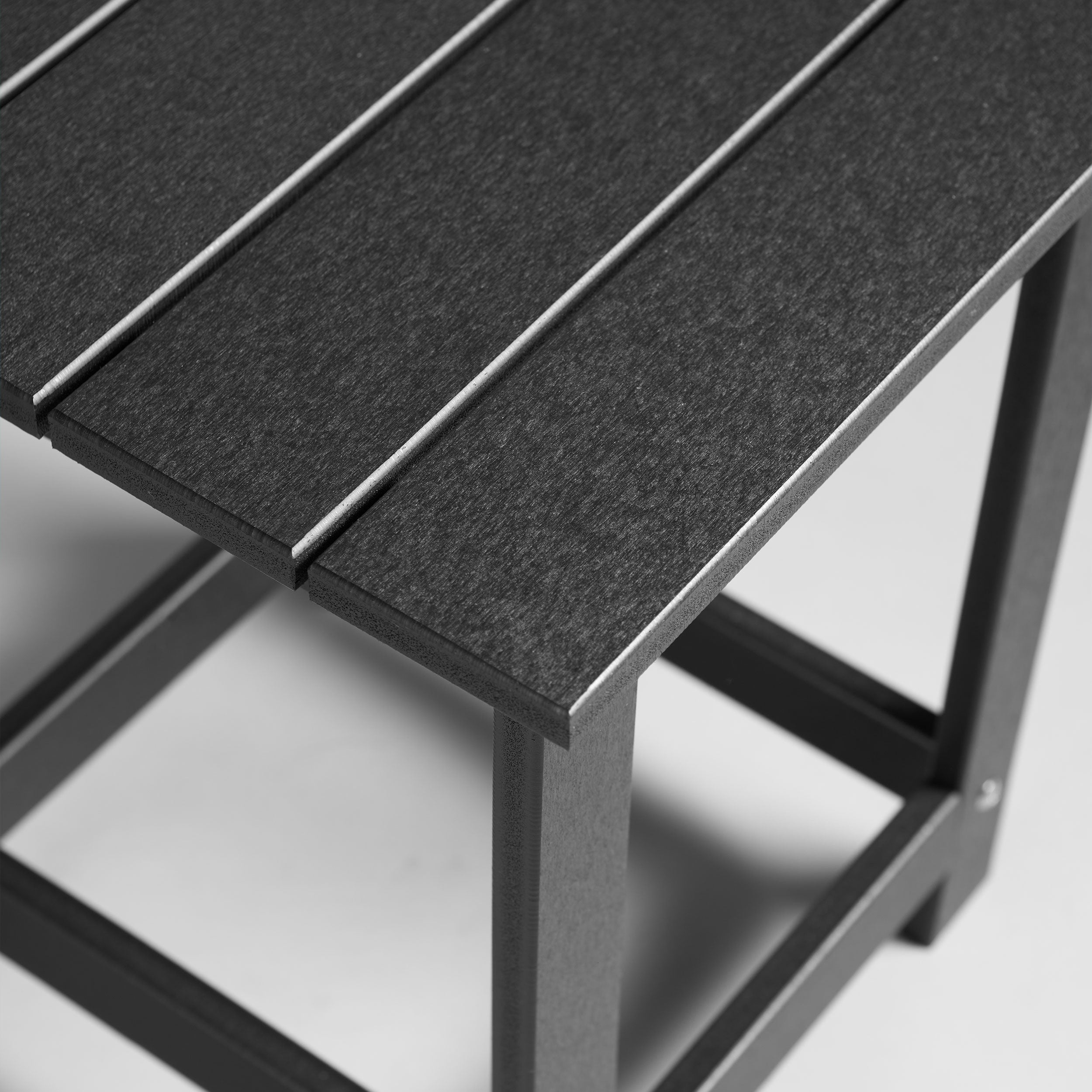 Close-up of a black outdoor table featuring the fine textures of the tabletop. 