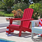 Red Adirondack chair by a pool with a striped towel and sandals on a sunny day. 